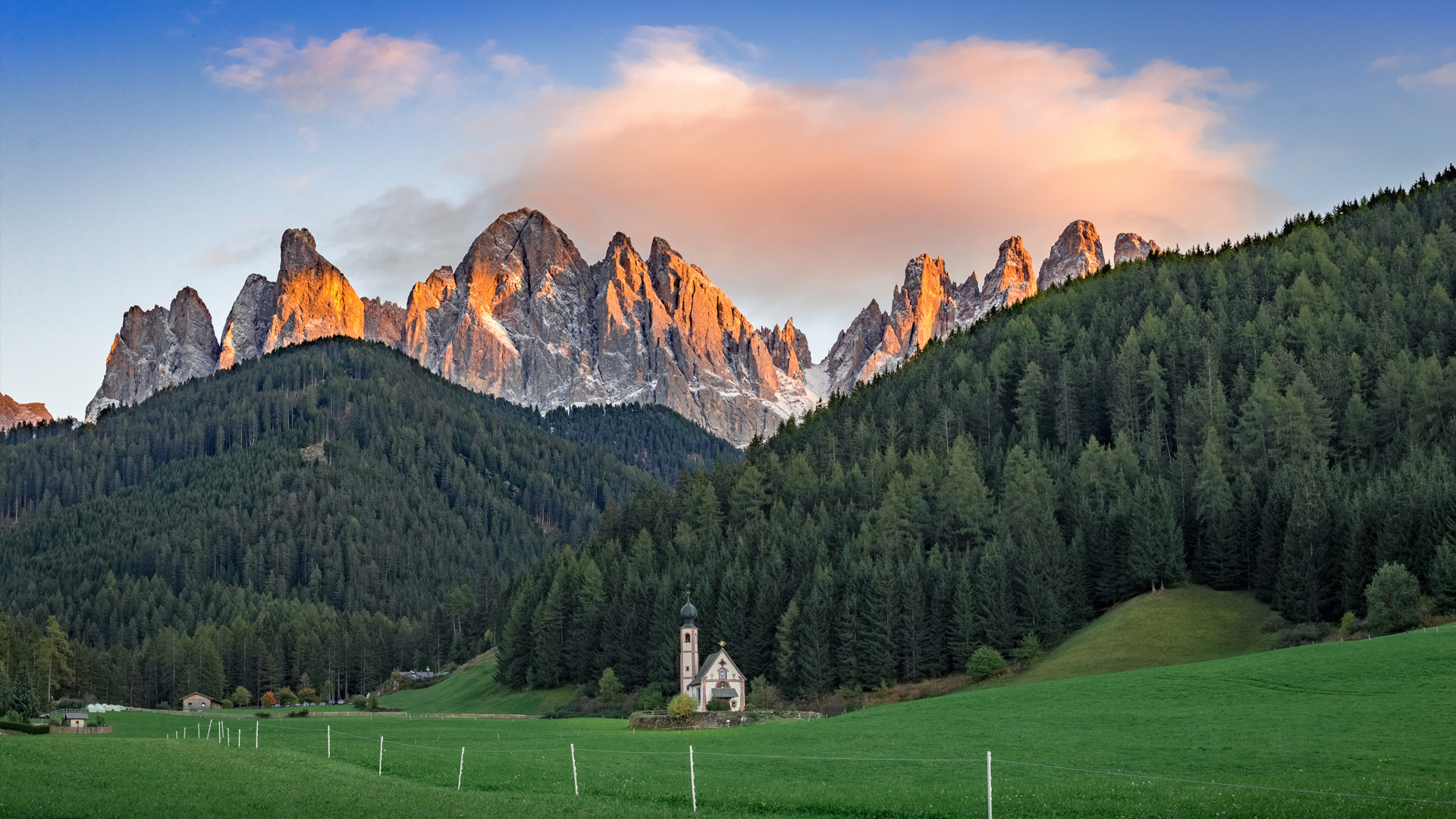 A house on green grass with a mountain in the background.